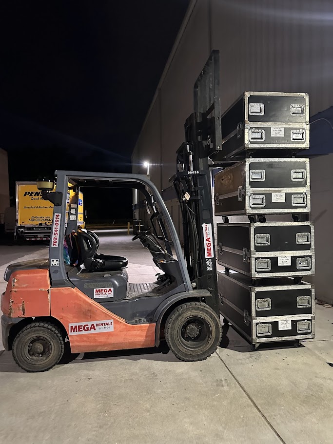 Stacked road cases loaded by forklift for delivery to an event
